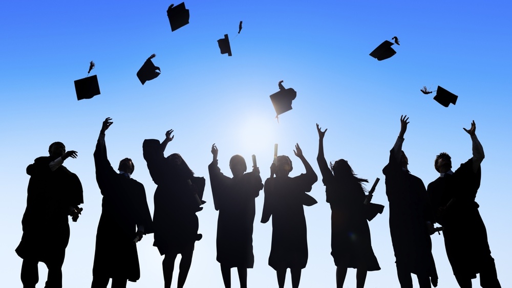 Stock Photo Silhouette of Graduates throwing their Caps into the Sky