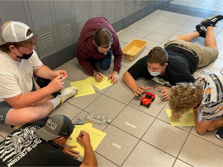 Students test the speed of cars in a laboratory group.