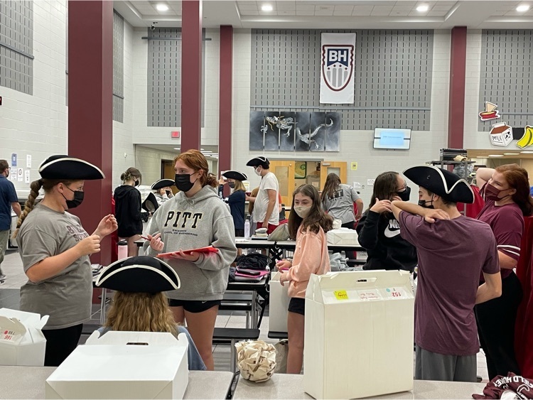 Marching band students try on their marching band hats.