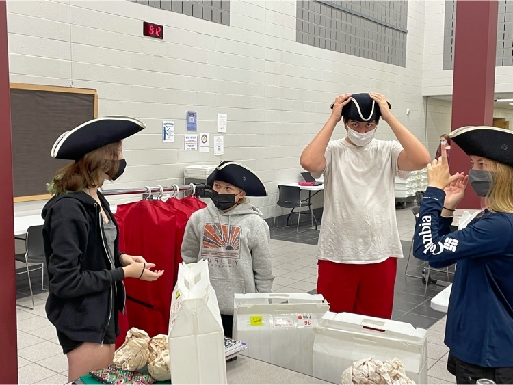 Students in marching band try on their uniforms and hats.