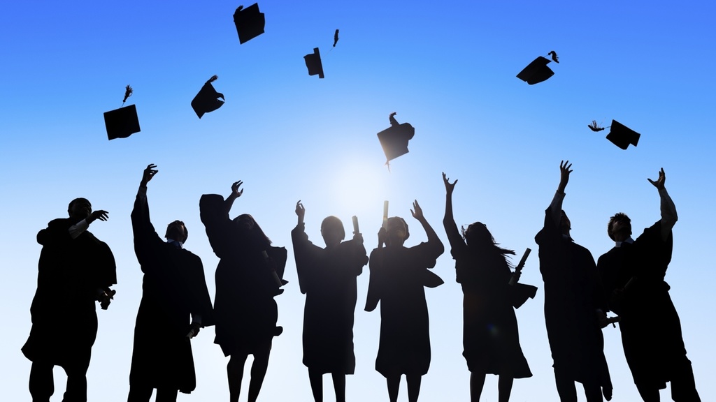 Stock photo - silhouette of graduates throwing their caps into the sky